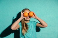Child girl holding oranges healthy food on teal ba 2021 08 30 08 49 41 utc