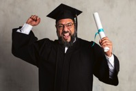 Happy senior man in a graduation gown holding his 2021 09 02 06 05 28 utc