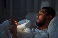 Man with smartphone in bed at night P3U9SAN