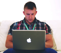 Man Using Macbook While Sitting on White Sofa Free Stock Photo