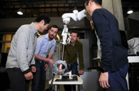 A team of mechanical engineers from Johns Hopkins University are developing a SMART robot (Smart Tissue Autonomous Robot) that can perform soft tissue surgeries such as intestinal reconnections. Left to right, looking at the robot: Jin Kang, professor of electrical and computer engineering; Justin Opfermann, Ph.D. student, Axel Krieger, assistant professor of mechanical engineering; Michael Kam, Ph.D.. student. (Barbara Haddock Taylor/Baltimore Sun)