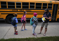 Students are given bus stickers after getting off the bus at Northeast Elementary School in Jackson on Tuesday morning, Aug. 25, 2020. Jackson Public Schools buses will soon begin delivering WiFi into neighborhoods where district families can't afford internet access.J. Scott Park | MLive.com