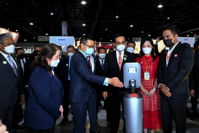 Mr Deng (left) highlights Huawei's smart solutions during a visit by Prime Minister Prayut Chan-o-cha (centre left) to the company's booth at the fair.