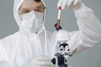 Person Using Microscope While Holding Test Tube Free Stock Photo