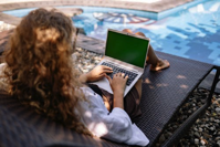 Woman on Laptop by Pool