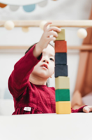 Selective Focus Photo of Young Girl in Red Dress Playing with Building Blocks Free Stock Photo