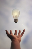 lightbulb suspended above hand