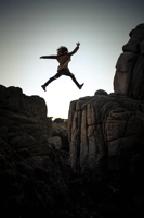 risk - Woman jumping over a chasm