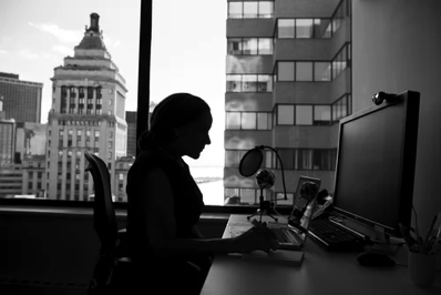 Entrepreneur - Woman sitting at desk working on computer.