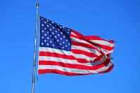 US Flag flowing in the breeze against a blue sky