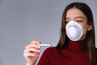 Woman in Face Mask Checking Thermometer Free Stock Photo